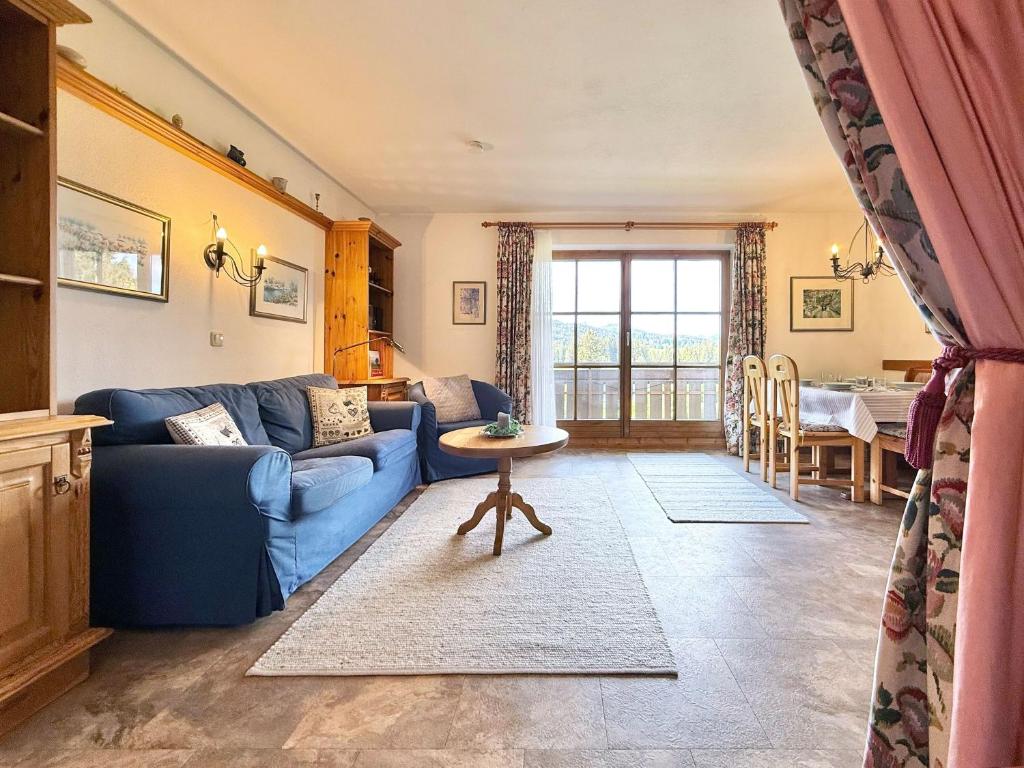 a living room with a blue couch and a table at Sonnenhof Seeg 01 in Seeg