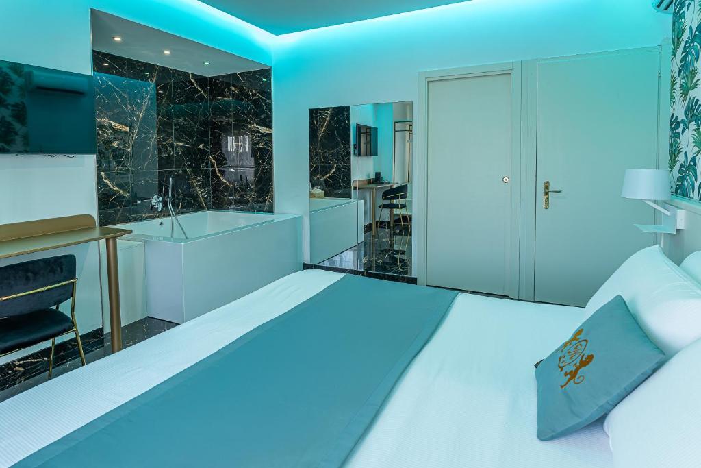 ein Schlafzimmer mit einem weißen Bett und blauer Beleuchtung in der Unterkunft Hotel Max in Aversa
