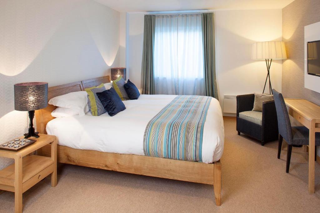 a hotel room with a bed and a desk and a chair at St Moritz Hotel and Cowshed Spa in Polzeath