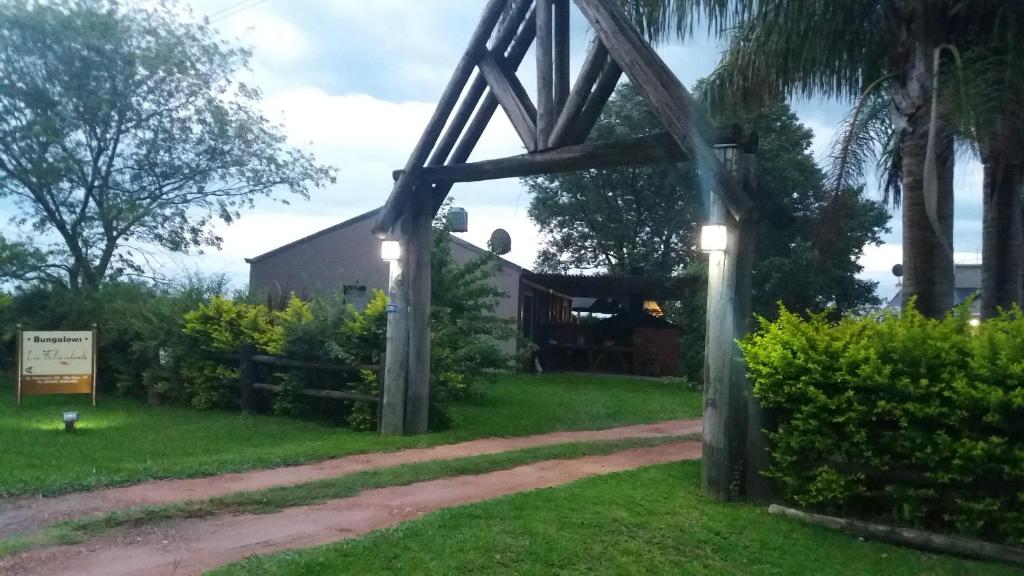 a gate to a house with lights in the grass at La Felicidade in Villa Elisa