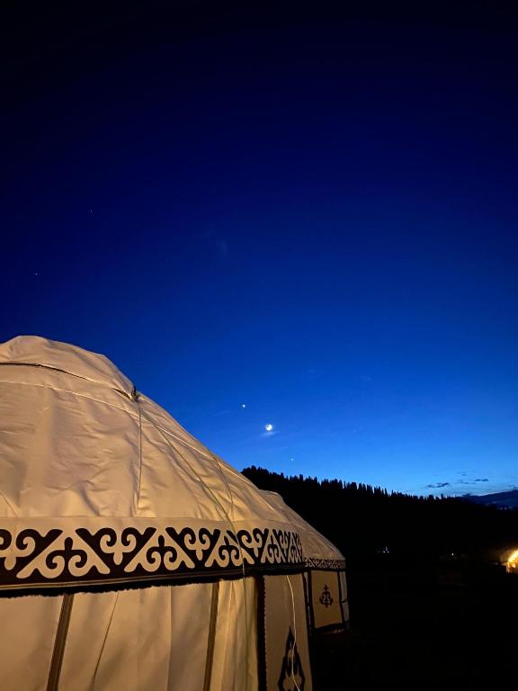 a white tent with the moon in the sky at Альфира in Dzhergalan