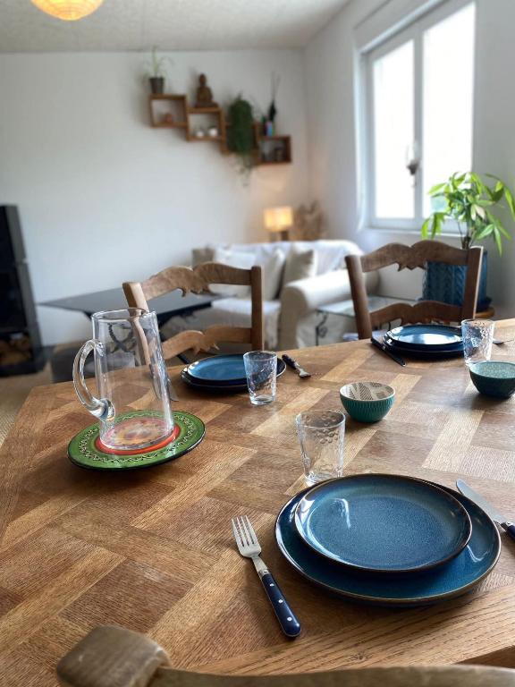 a wooden table with plates and utensils on it at Maison avec sauna en Presqu'île de Crozon pour 6 personnes in Crozon