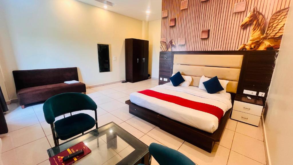 a bedroom with a bed and a table and a chair at Crystal Park Hotel And Restaurant in Lalru