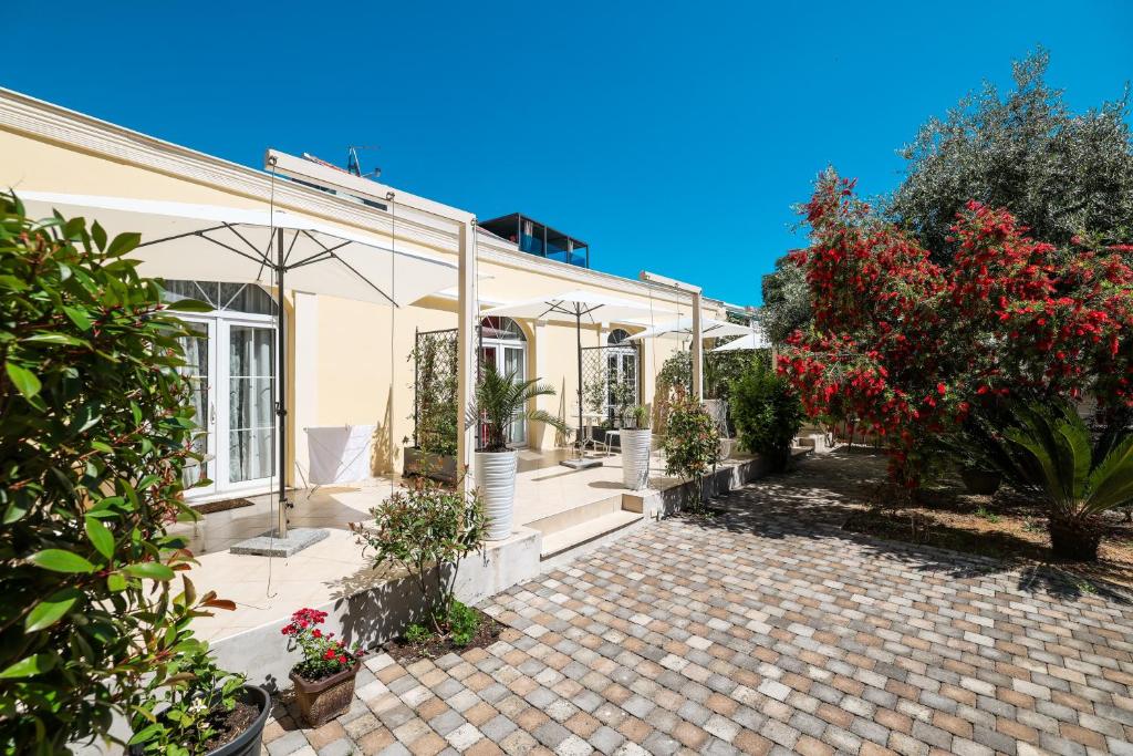 a house with a patio with flowers and plants at Guesthouse Villa Maggie by Adex travel in Zadar