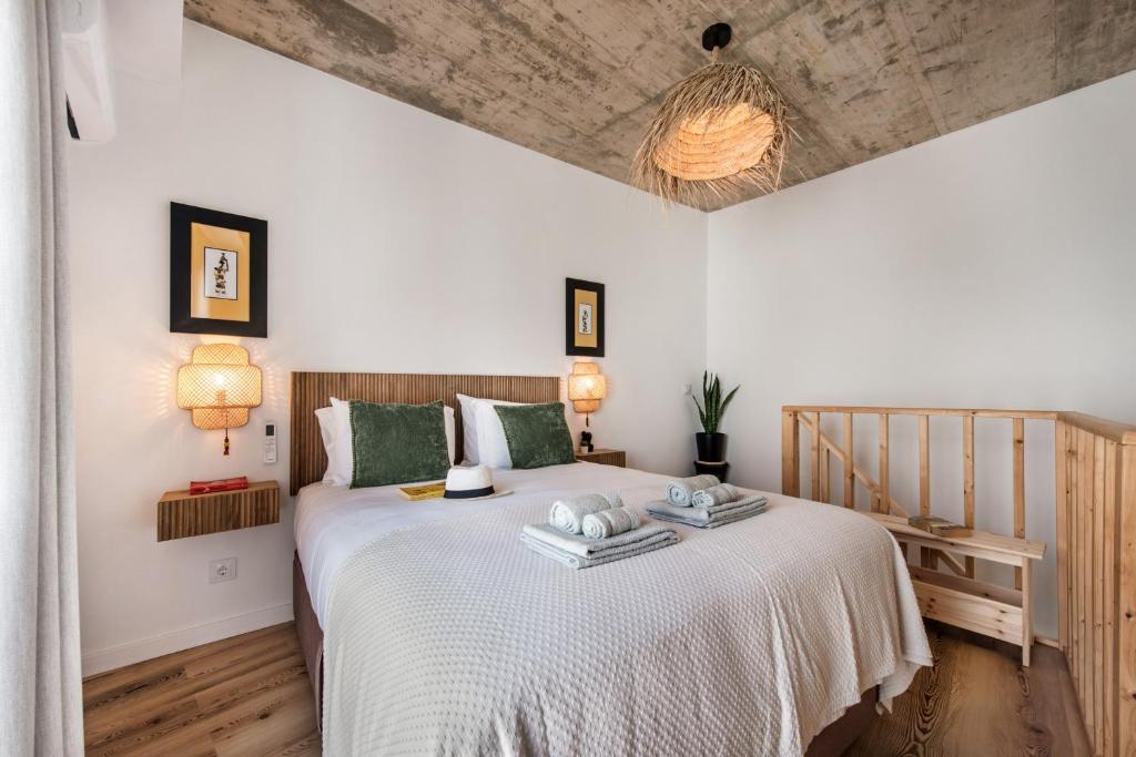 a bedroom with a large white bed with green pillows at Casas dos Machados in Tavira