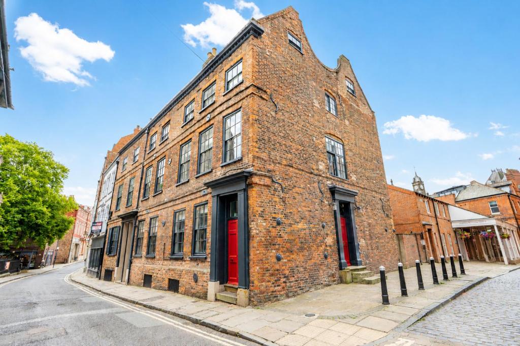 a brick building with a red door on a street at Friargate House in York