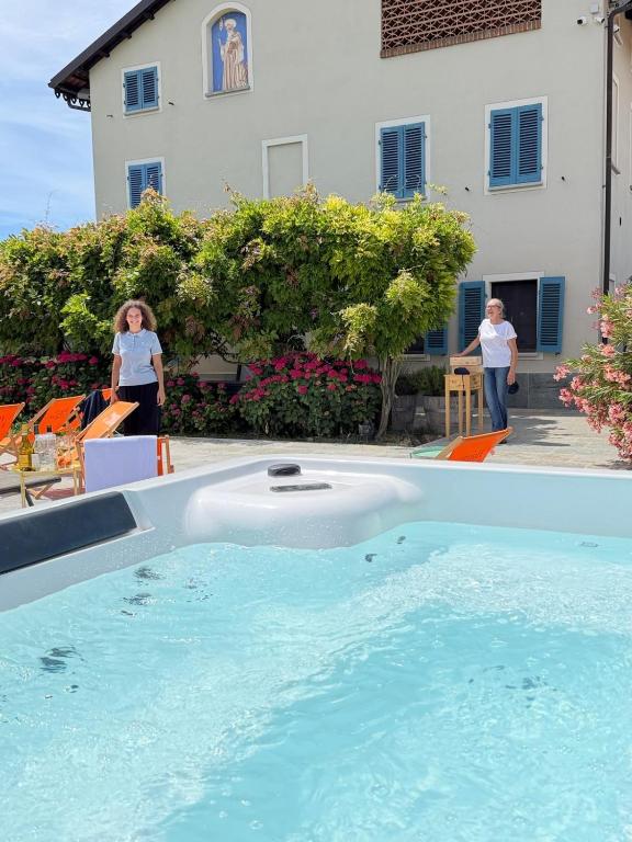 two women standing in front of a swimming pool at Braida Wine Resort in Rocchetta Tanaro