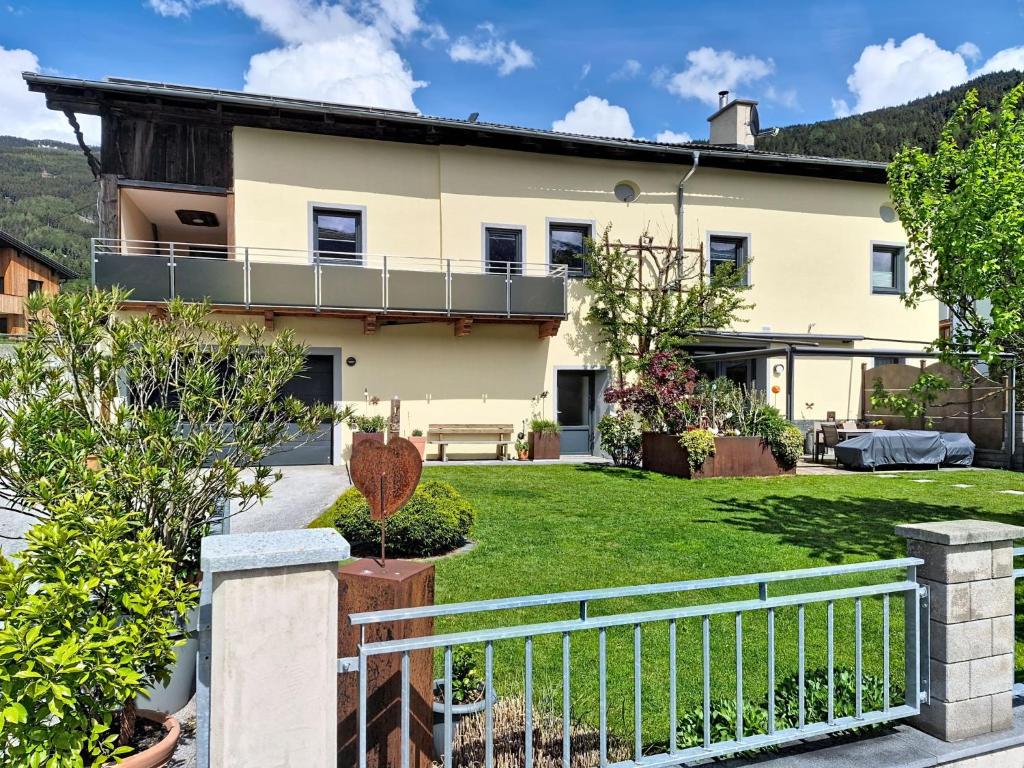 a house with a white fence and a yard at Apartment Halbeis by Interhome in Matrei am Brenner