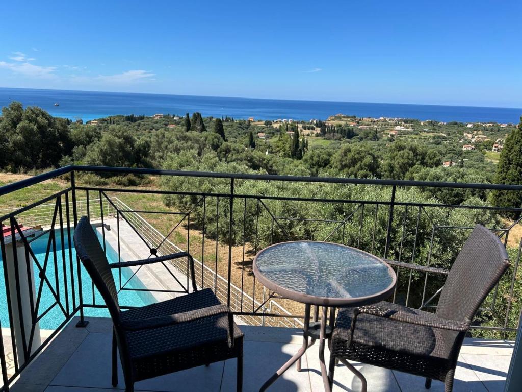 a balcony with a table and chairs and the ocean at Captains View in Kefallonia