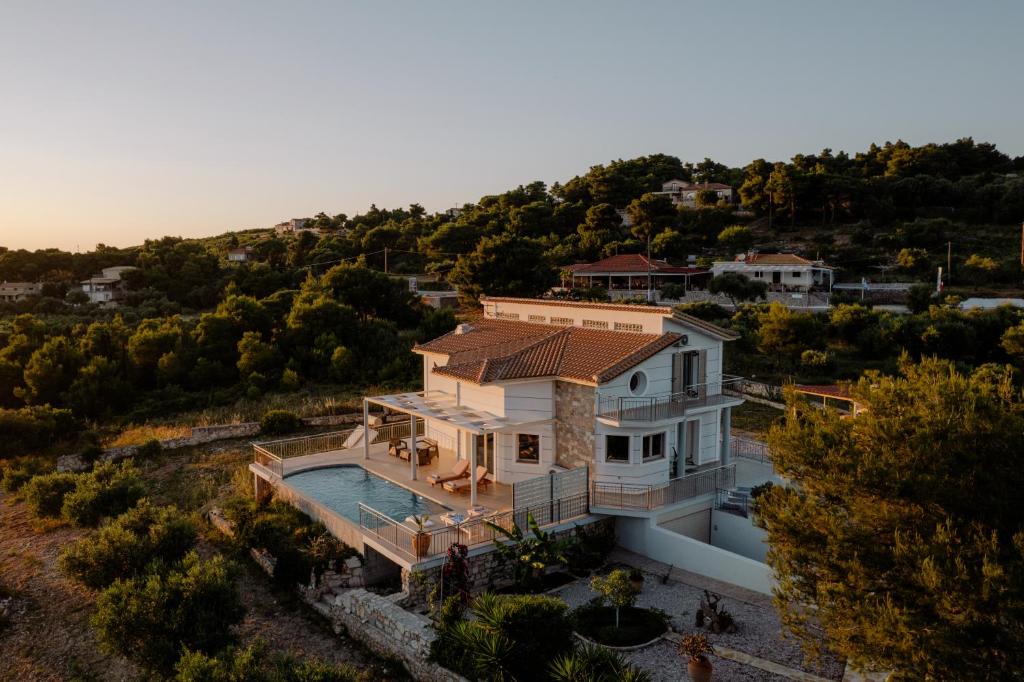 an aerial view of a white house with a roof at Villa Guesto with Private Pool by MindYourVilla in Anafonítria