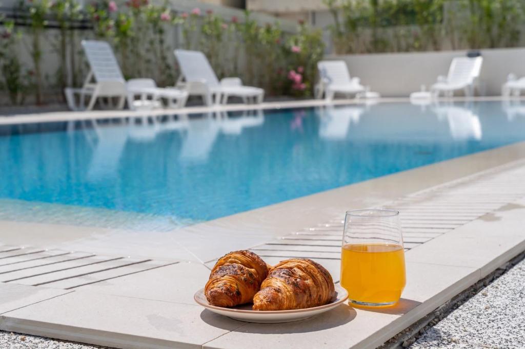 a plate of croissants and a glass of beer next to a pool at Luxury Residence Mauro in Makarska