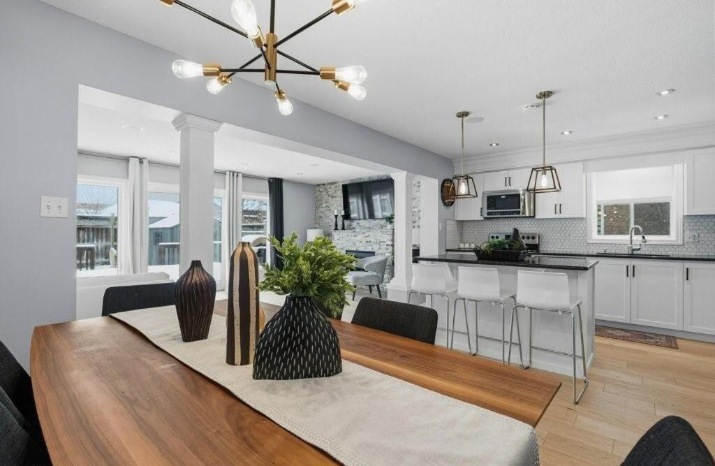 a kitchen and living room with a dining room table at Cozy Kitchener-Waterloo Home in Kitchener