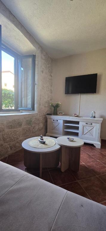 a hotel room with two tables and a television at Apartmani Furesti1 in Donji Stoliv