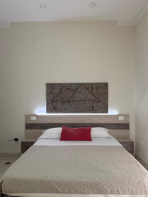 a bedroom with a large bed with a red pillow at Donna Vicenza Bed & Breakfast in Naples