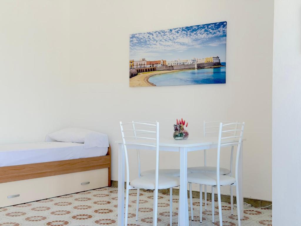 a bedroom with a table and chairs next to a bed at Baia Verde - Dimitri House in Baia Verde