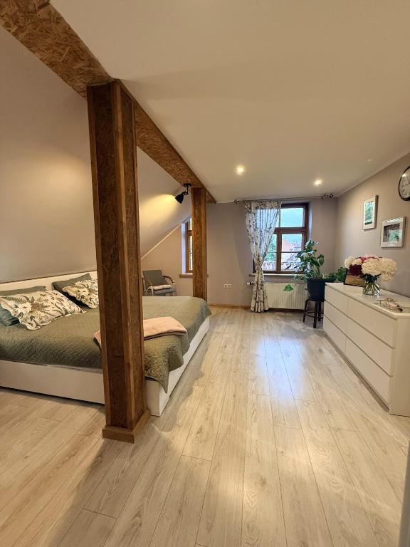 a bedroom with two beds and a wooden floor at Rose & Vintage Mansard in Kuldīga
