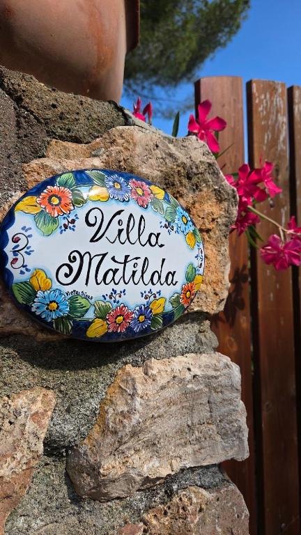 a sign on the side of a wall with flowers at Villa Matilda ad Ansedonia in Orbetello
