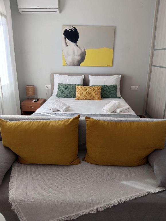 a bedroom with a large bed with yellow pillows at Little Dream House in Valanidorachi