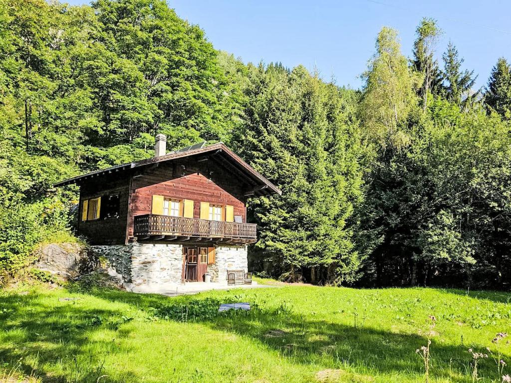 a small house in a grassy field with trees at Chalet Le Châtelaret by Interhome in Finhaut
