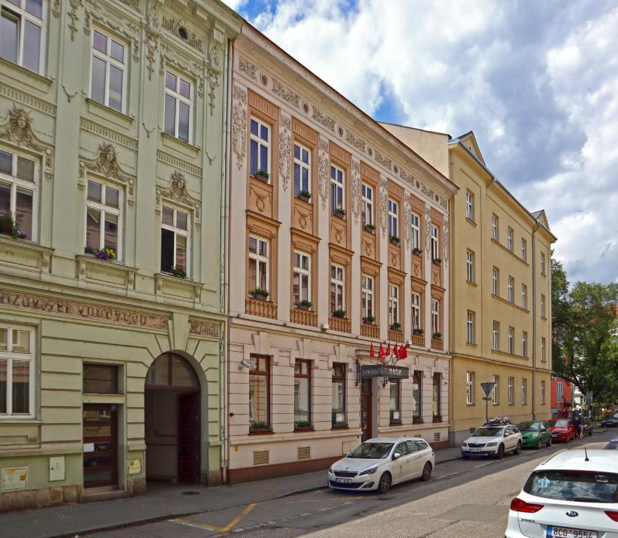 a building with cars parked in front of it on a street at Hotel Maria in Ostrava