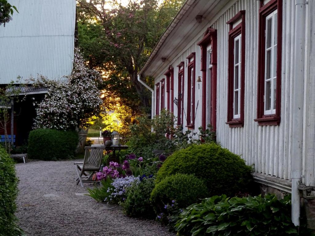 una casa con un banco y flores delante de ella en Sannagård B&B, en Falkenberg