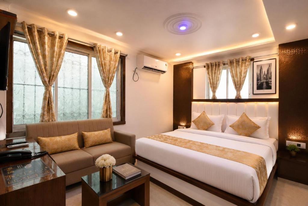 a bedroom with a large bed and a couch at Golden Palace in Kolkata