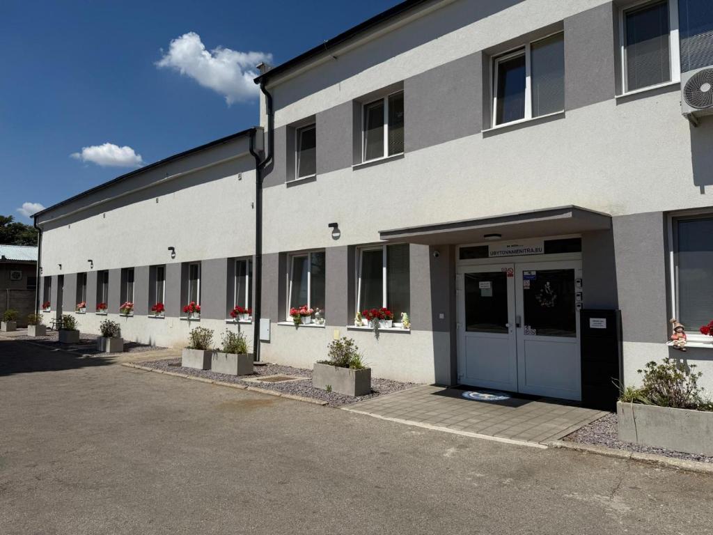 a large white building with a door and some plants at Ubytovanie Nitra in Nitra