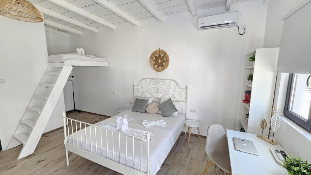 a small white bedroom with a crib and a bunk bed at Thea's Bungalow in Costinesti