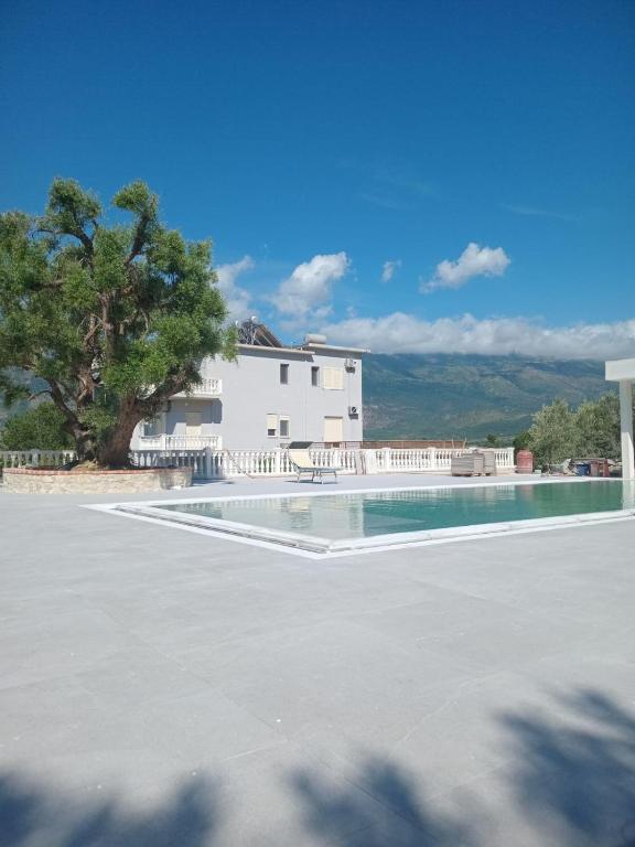 a swimming pool in front of a white house at Villa RESA - Intero allogio in Orikum