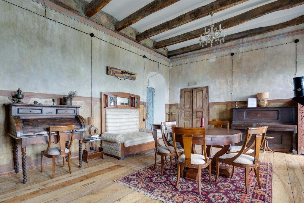 a dining room with a table and a piano at Lurji Bani in Sighnaghi