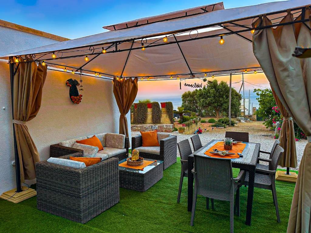 a patio with a table and chairs and an umbrella at VILLA MADRE in Marina Serra