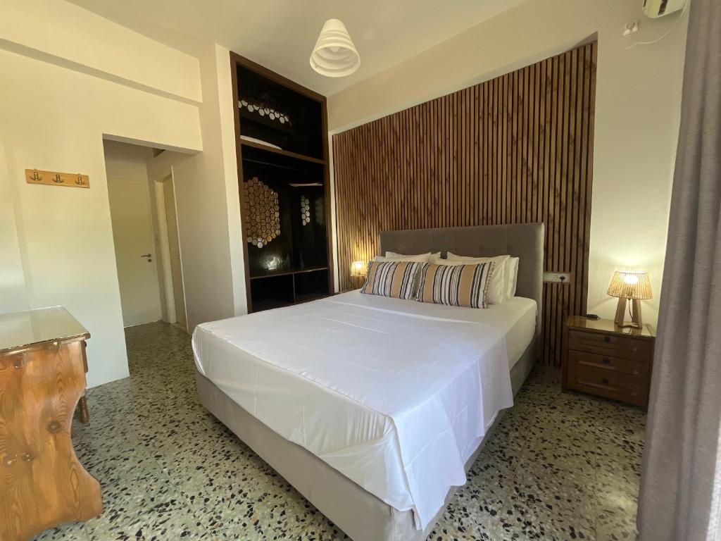 a bedroom with a large white bed and a table at Nikos Studios Apts & Suites in Keri