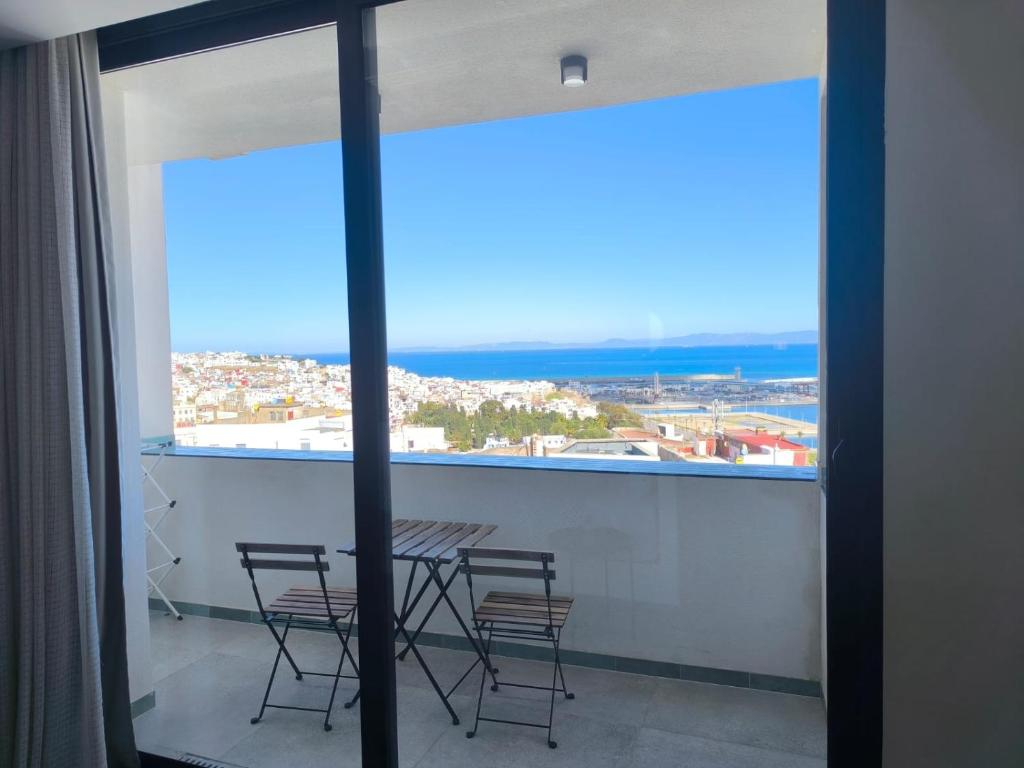 a table and chairs in a room with a large window at YaYaCaSa in Tangier