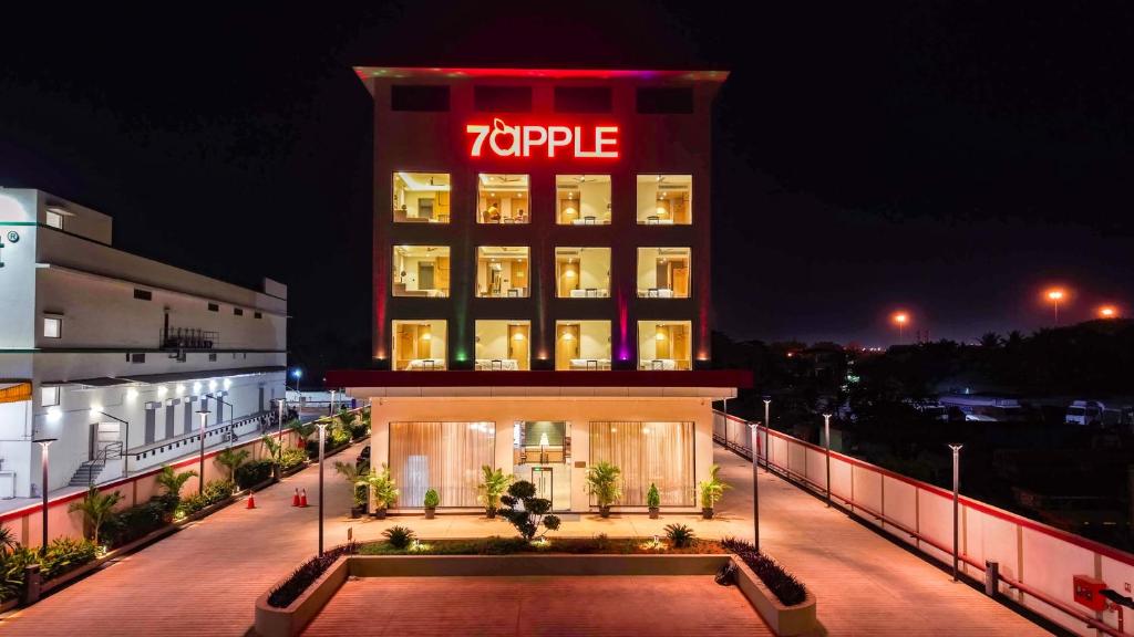 a hotel with a sign on top of it at night at 7 Apple Hotel Visakhapatnam in Visakhapatnam
