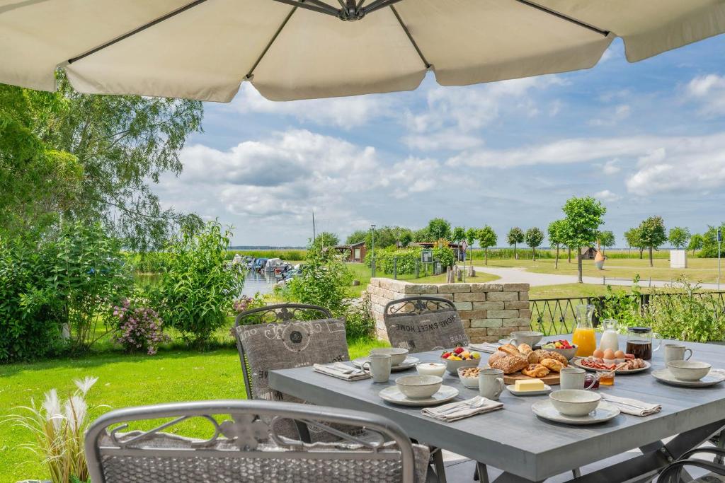 a table with food on it under an umbrella at Ferienhaus Seebrise in Loddin