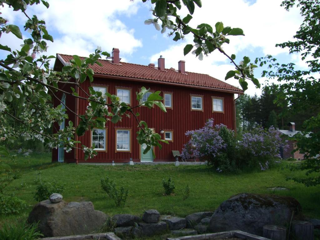 a red house with a garden in front of it at Allsta Gård Kretsloppshuset B&B in Bjärtrå