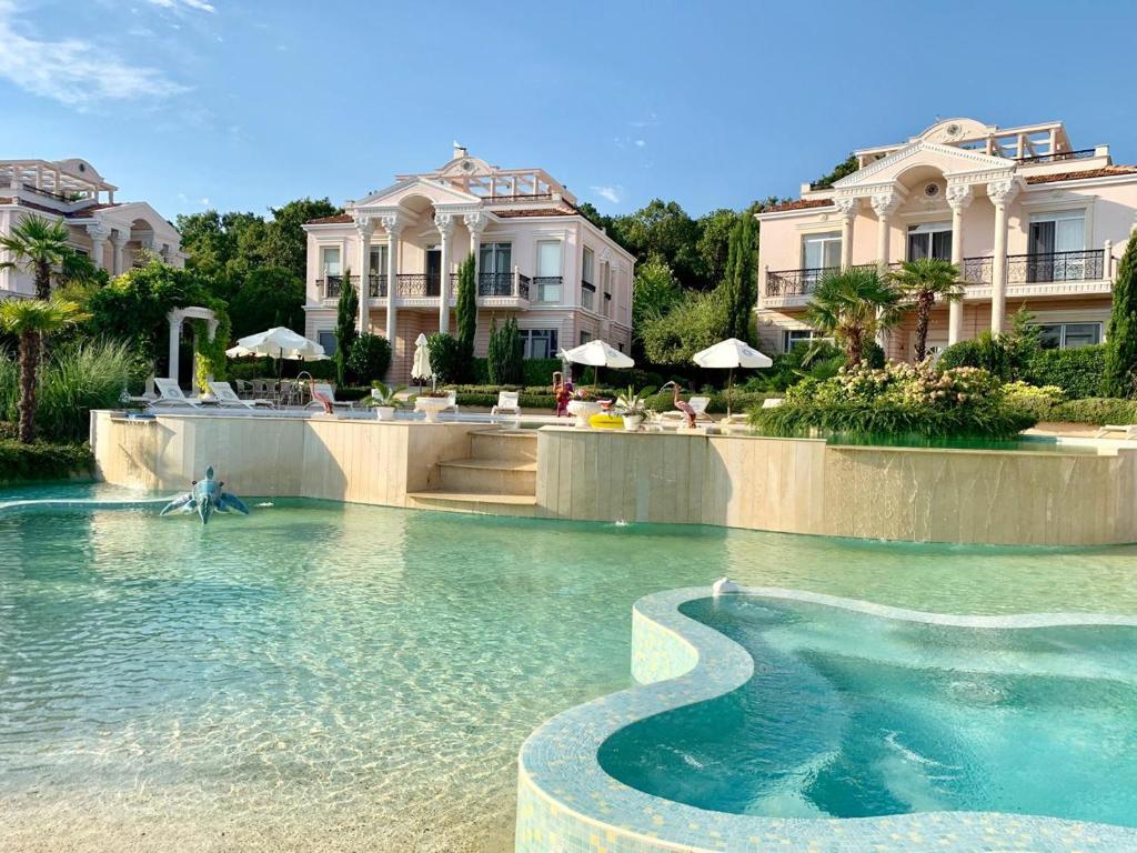 a swimming pool in front of a large house at Olympia Sozopol in Sozopol