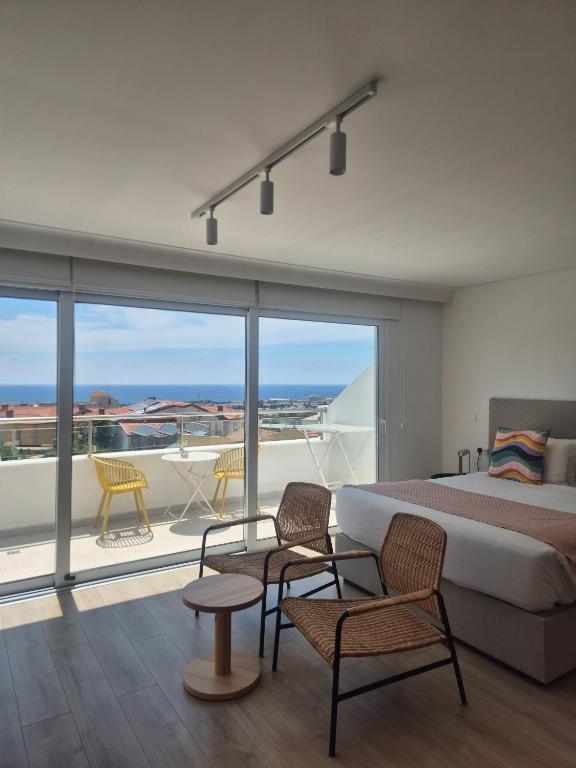 a bedroom with a bed and chairs and a balcony at Old Town 63 Luxury Residence in Paphos