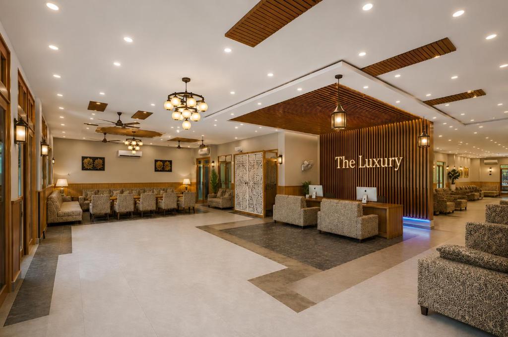 a lobby at the library with chairs and a waiting room at Hotel The Luxury Delhi Airport in New Delhi