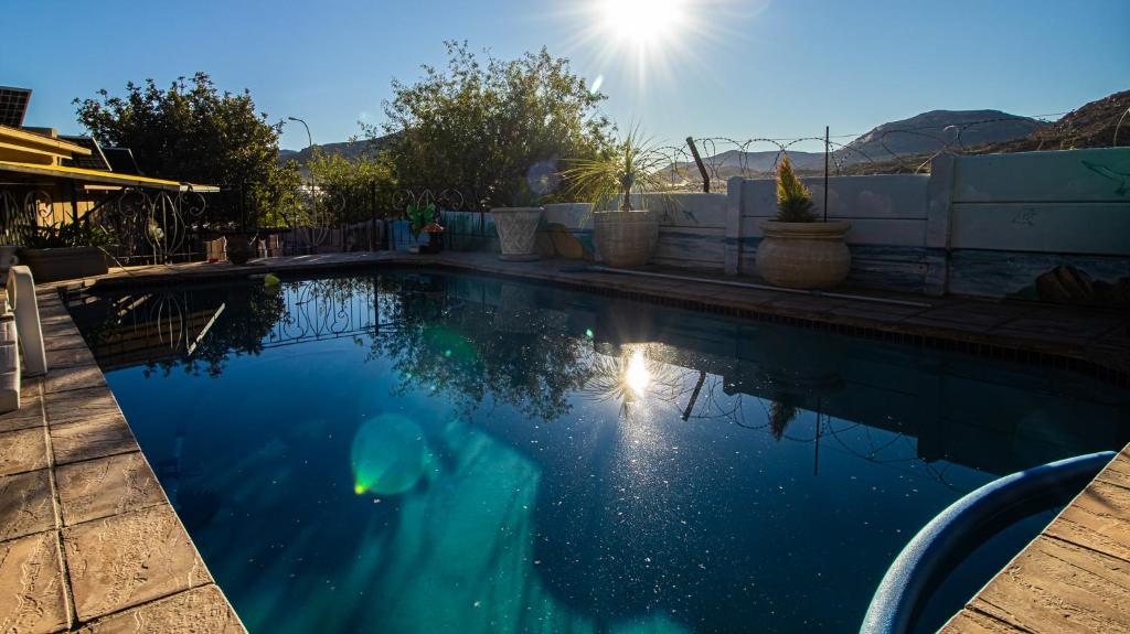 a swimming pool with the sun reflecting in the water at Home Sweet Home in Springbok