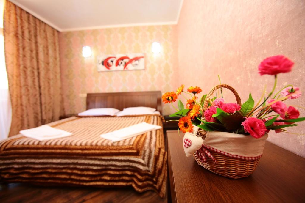 a hotel room with a bed and a basket of flowers at Orbi Sea Towers Apart Hotel in Batumi