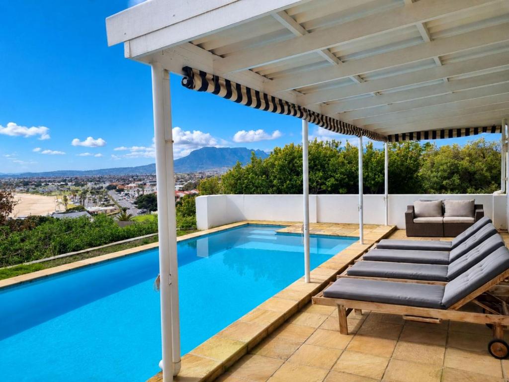 a swimming pool with a pergola on a house at Amazing View Villa, Sleeps 9 in Gordonʼs Bay