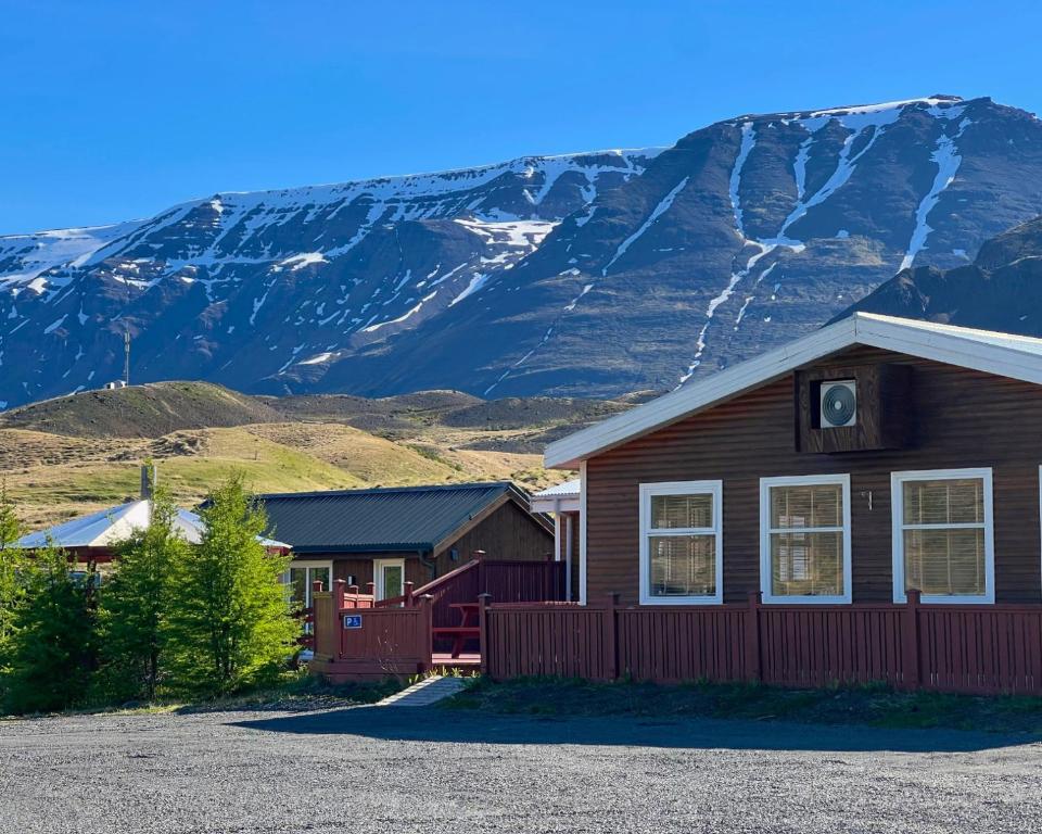 a house with a mountain in the background at Engimyri Lodge in Akureyri