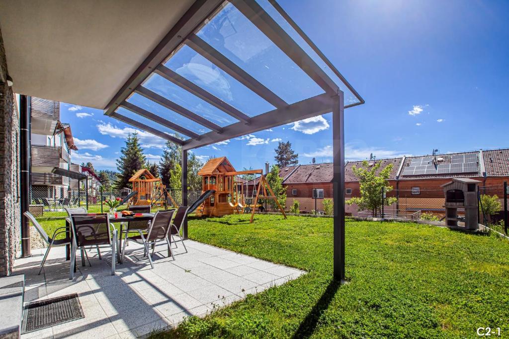 a patio with a table and chairs in a yard at KORZO LIPNO C in Lipno nad Vltavou