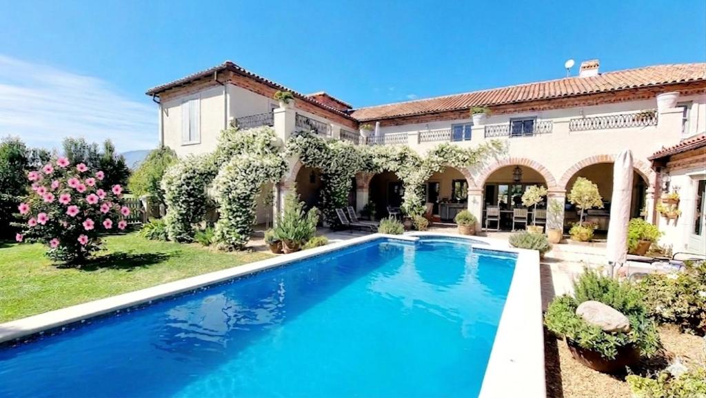 a swimming pool in front of a house at Sandmartins Private Secure Villa in Simondium