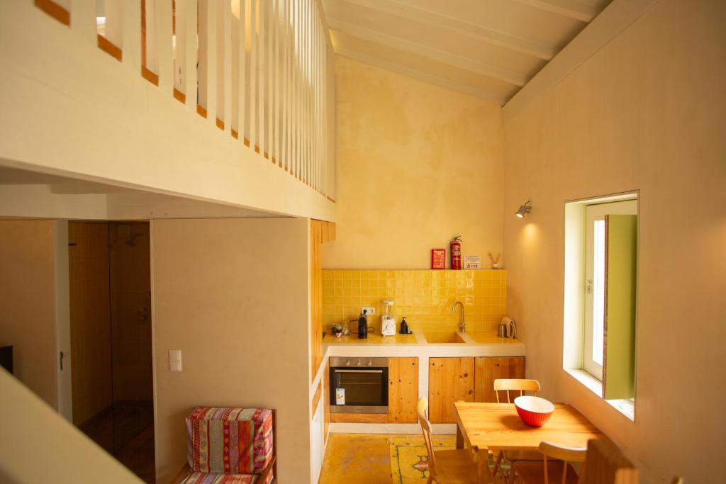 a small kitchen with a wooden table and a dining room at Estúdio 24 na Boavista, JAMBA House in Porto