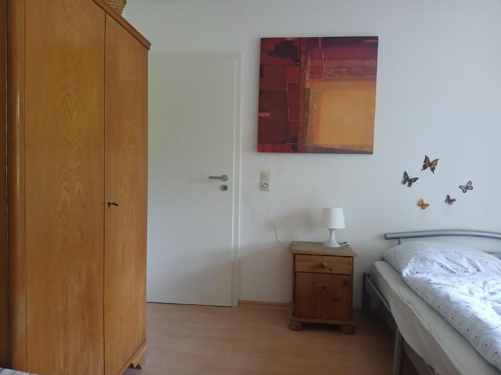 a bedroom with a bed and a wooden cabinet at Unser Haus am Weinberg in Alsheim