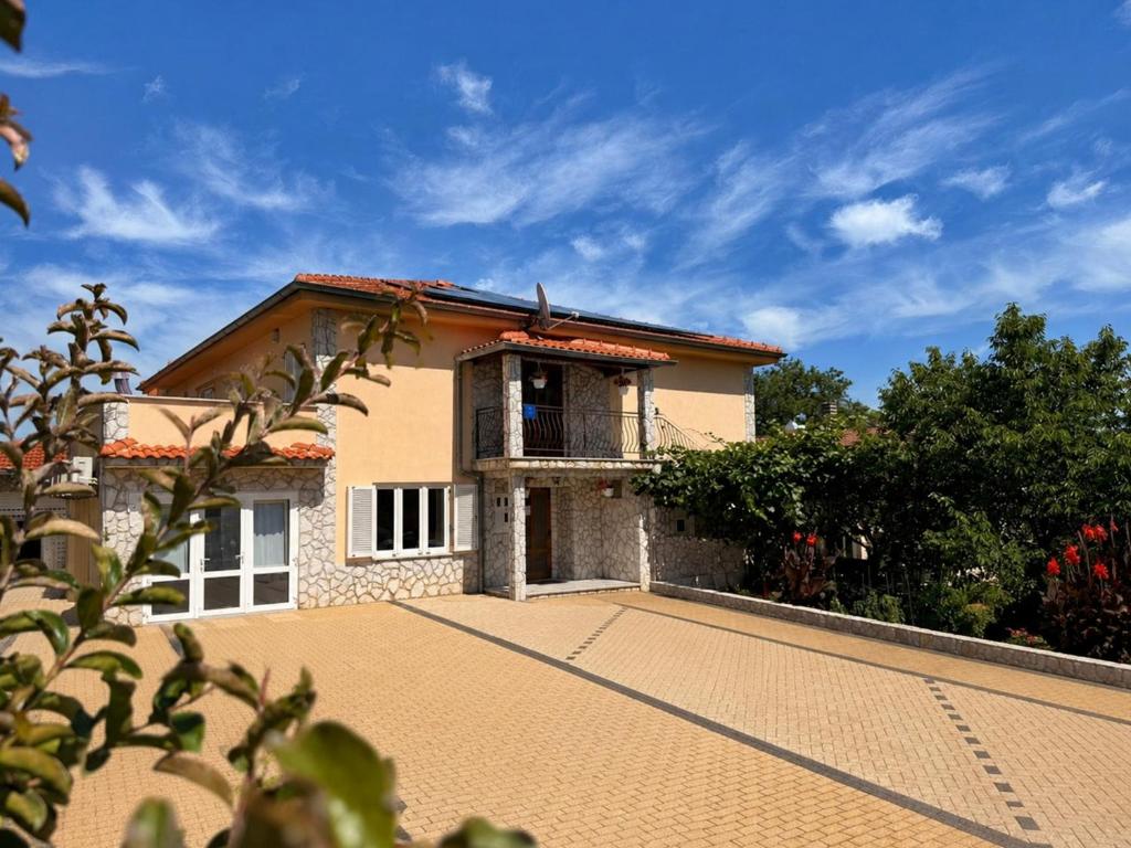 a house with a driveway in front of it at Apartments Nevenka K. in Čižići