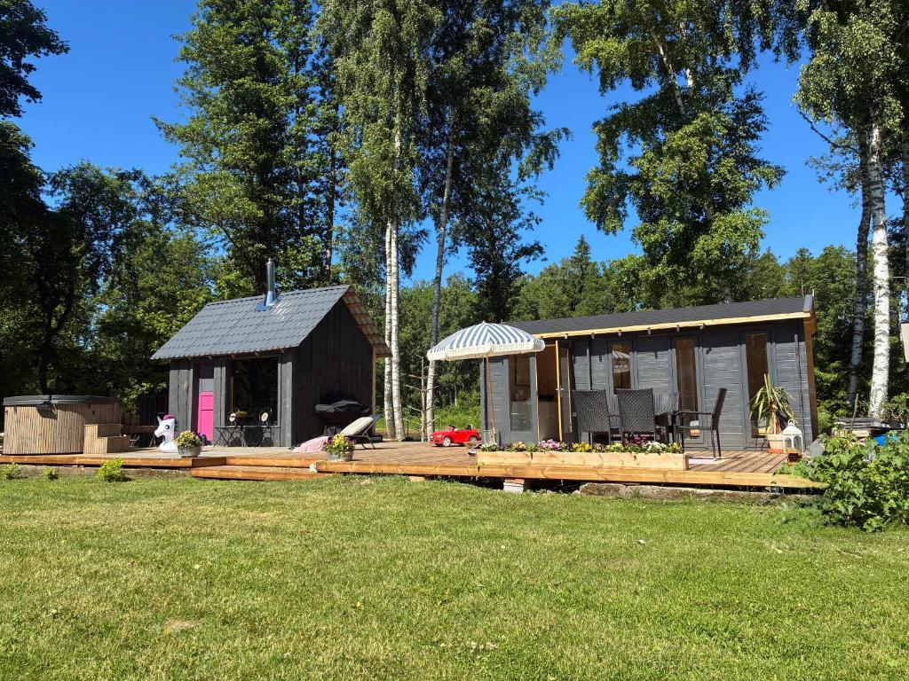 a small cabin with a deck in a yard at Haapsi Hideaway Garden Cabin in Haapsi