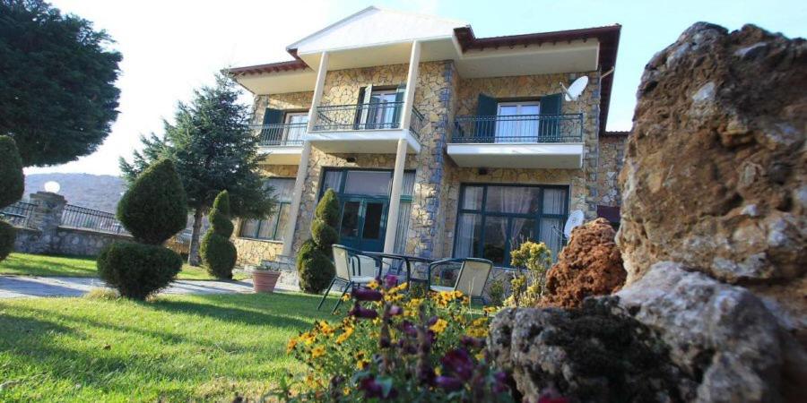 a large house with a yard with flowers in front of it at Krystal Hotel in Krystallopigí